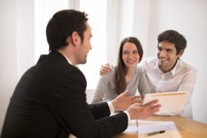 real estate agent speaking with happy couple