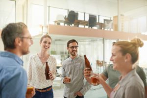 a group of young professionals talking while drinking beer