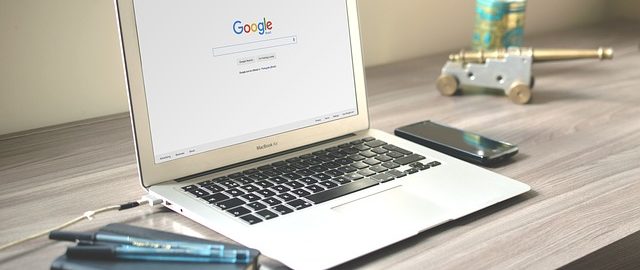 a lap top sitting on a desk displaying a google web search