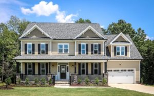 exterior of large suburban home with two stories front porch and garage.