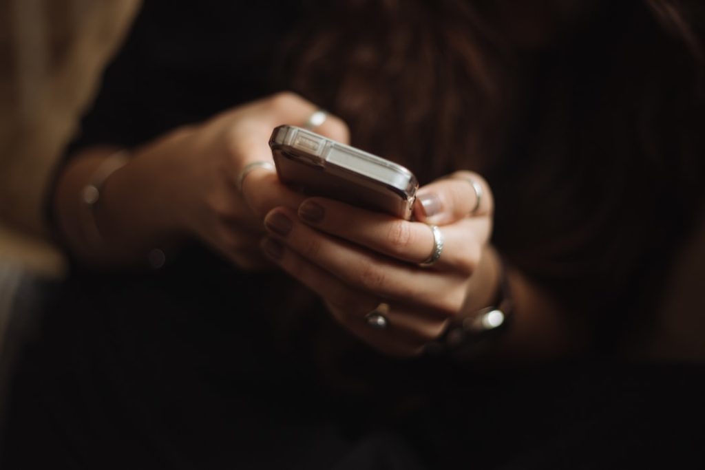 A person on their cell phone using social media logins.